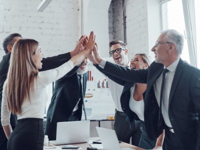 cheerful-business-team-giving-each-other-high-five-to-success-while-working-in-the-modern-office.jpg
